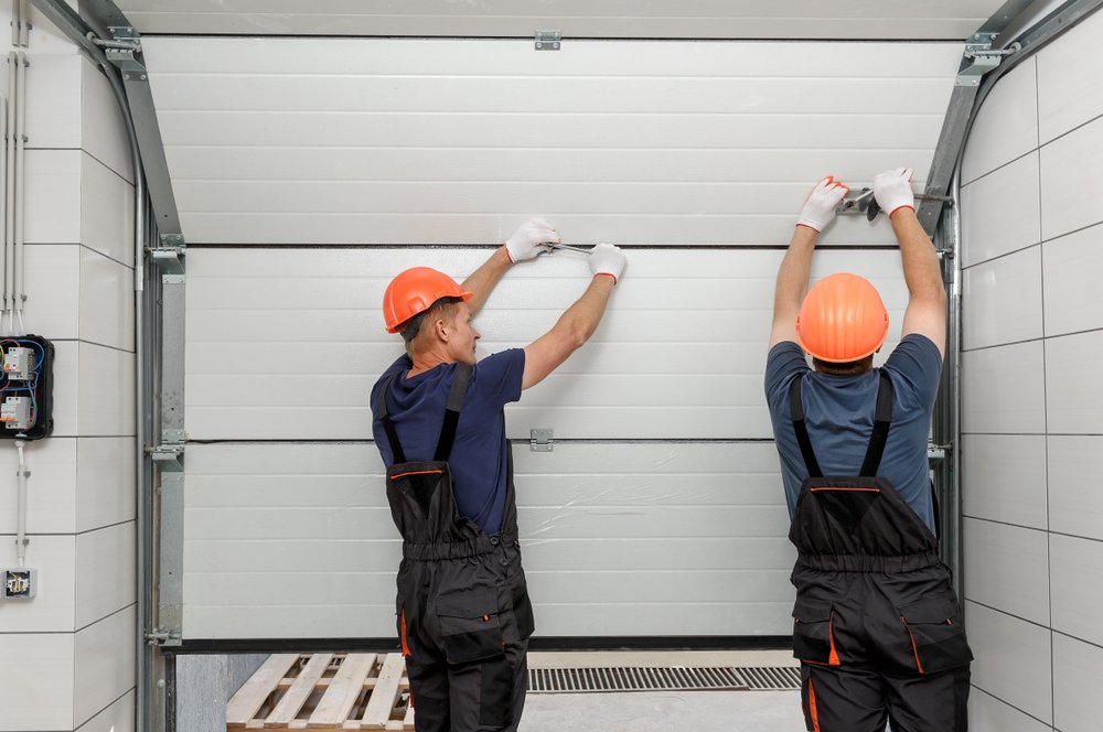 Workers are installing lifting gates of the garage - garage door repair New Orleans - ace garage door