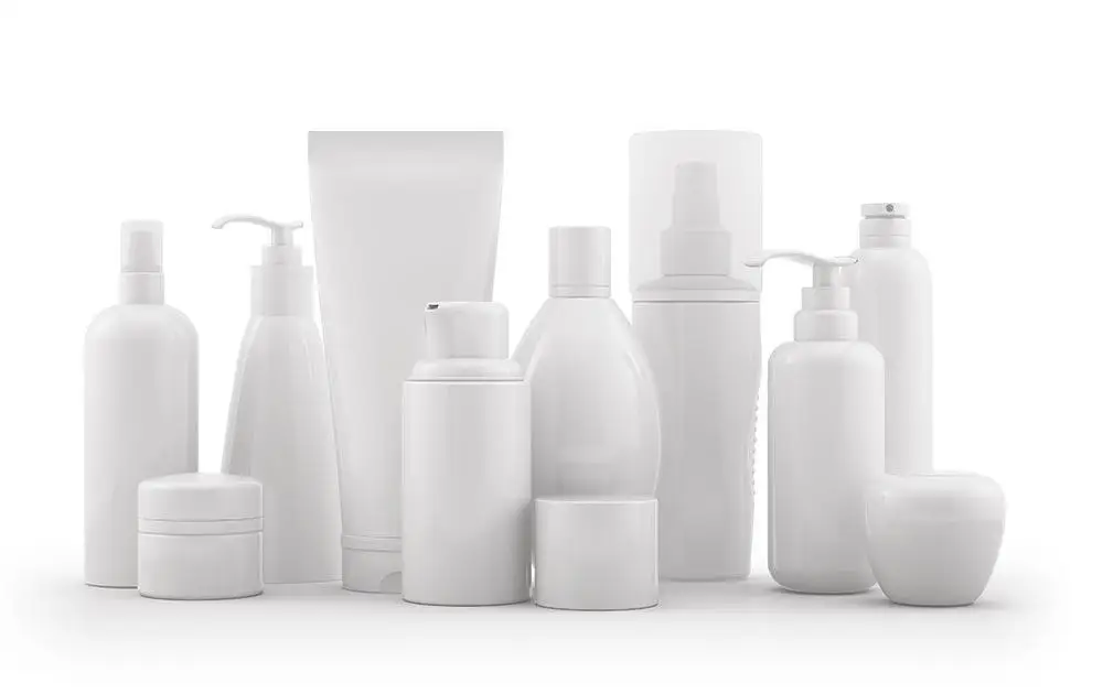 Variedad de botellas y recipientes de cosméticos blancos dispuestos sobre un fondo blanco, incluidas bombas y botellas de spray.