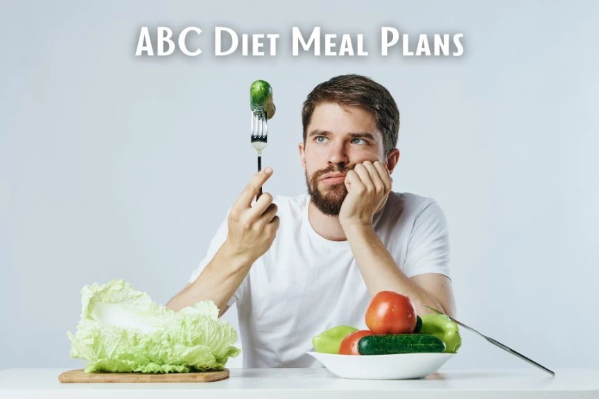A man looks at a single cucumber on a fork with a bored expression, surrounded by vegetables, illustrating the restrictive nature of the ABC diet.