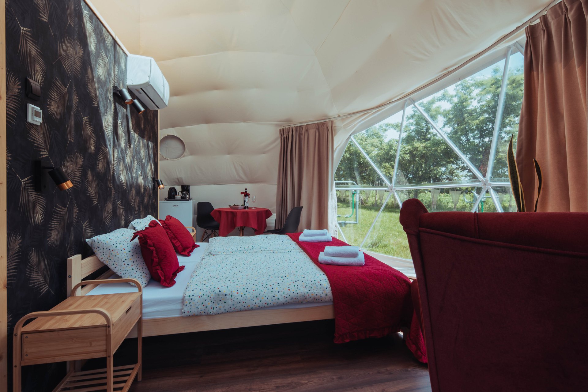 duże łóżko, meble oraz widok z namiotu