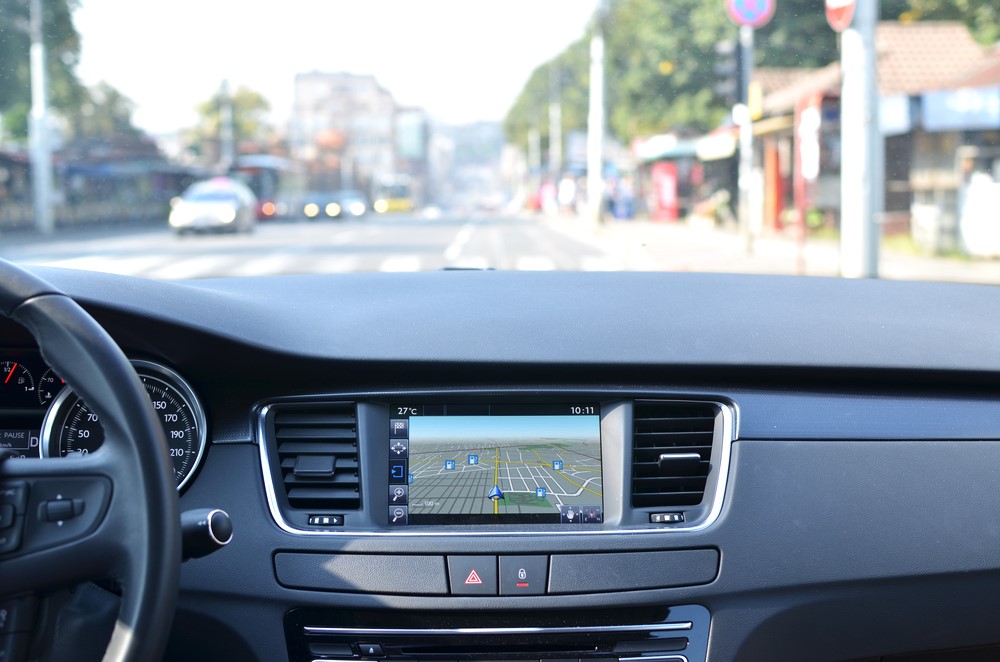 View from inside a car on a part of dashboard with a navigation unit - auto glass repair new orleans